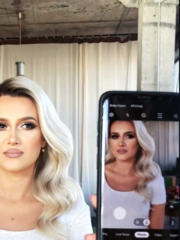 iLo having her makeup done in front of a mirror